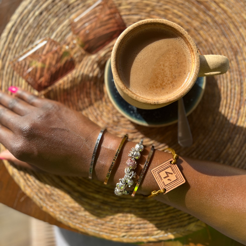 aesthetic image of brown coffee, brown sunglasses, and chocolate brown arm with jewelry